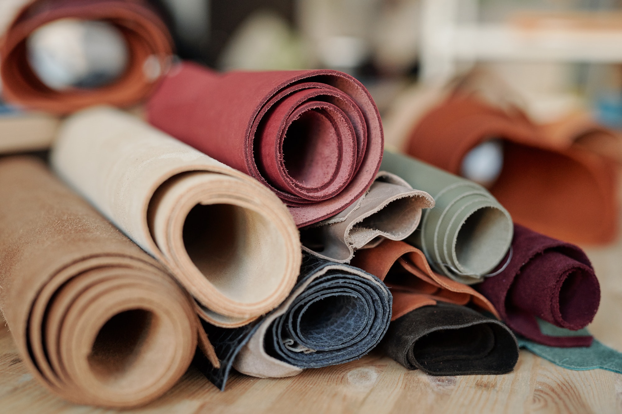 collection-of-rolled-suede-and-leather-of-various-colors-lying-on-wooden-table.jpg